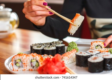 sushi and rolls, Japanese cuisine, a girl eating sushi in a restaurant