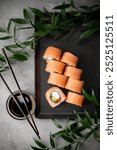 sushi rolls, set, chopsticks, avocado, caviar, cucumber, cream cheese, close-up top view, soy sauce, branch with green palm leaves, one piece