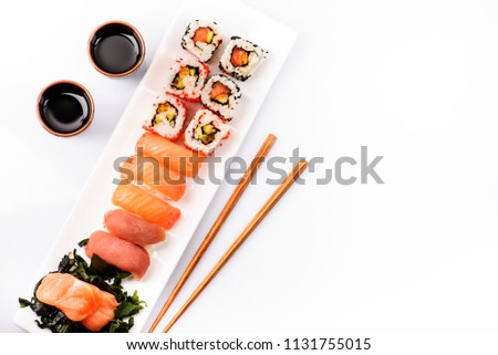 Sushi rolls set with salmon and tuna fish isolated on white background from above. Top view of traditional japanese cuisine. Asian food with chopsticks design.