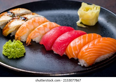 Sushi Salmon,sushi Tuna,sushi With Shrimp, Sushi With Eel On A Black Plate On Blue Concrete Table Macro Close Up