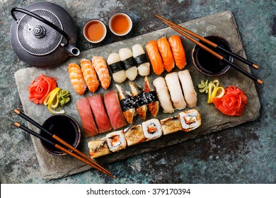 Sushi Set nigiri and sushi rolls with tea served on gray stone slate on metal background - Powered by Shutterstock