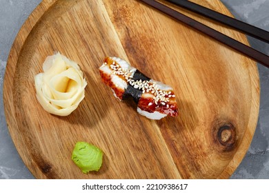 Sushi With Smoked Eel And Sesame Seeds On A Wooden Board. Japanese Dish Unagi Sushi.