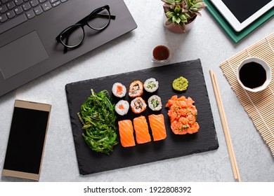 Sushi Takeaway At Work Desk Overhead. Eating Sushi For Lunch Break, Lunch Meal At Work, Top View