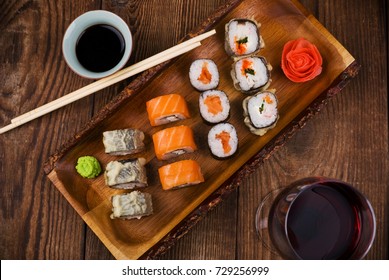 sushi and wine on wooden table, top view