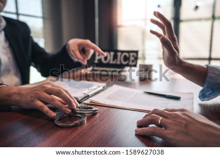 suspect with handcuffs being interviewed in interrogation room by Police officer, Criminal law concept