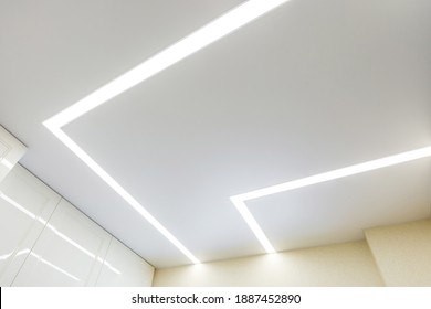 suspended ceiling with halogen spots lamps and drywall construction in empty room in apartment or house. Stretch ceiling white and complex shape. - Shutterstock ID 1887452890