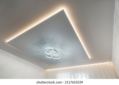 suspended ceiling with halogen spots lamps and drywall construction in empty room in apartment or house. Stretch ceiling white and complex shape. - Shutterstock ID 2117655539