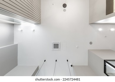 suspended ceiling with halogen spots lamps and drywall construction in empty room in apartment or house. Stretch ceiling white and complex shape. - Shutterstock ID 2245724481