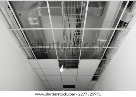 Suspended ceiling installation. Tiled metal frame indoors, low angle view