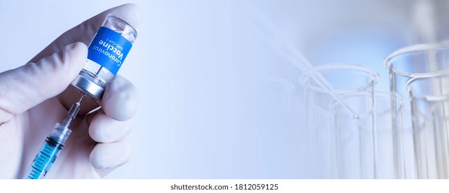 Suspended Covid-19 vaccine test - Man withdrawing liquid with syringe from the Sars-Cov-2 Coronavirus Vaccine vial - Test tubes at the bottom of the image - Space for text