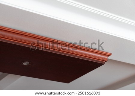 Suspended and grid ceiling with LED spots lamps and drywall construction in empty room in house interior. Stretch ceiling white and complex shape.