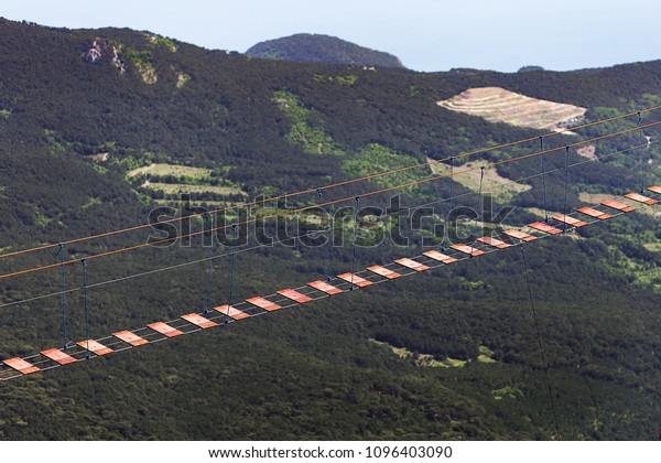 The suspended pathway over the precipice in the\
mountains where people go