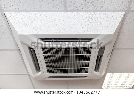 Suspended tile ceiling mounted big air-conditioner, close up view, office room