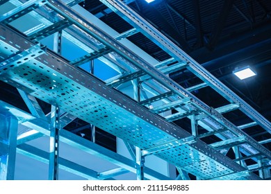 Suspended trays for electrical communication. Perforated trays of metal. Construction for laying wires and utilities. Place for electrical wires under hangar roof. Concept installation of utilities