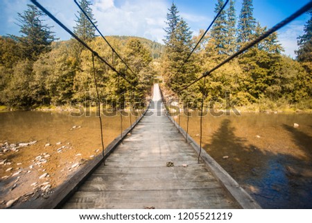 Suspension bridge. Landscape view of long wooden suspension bridge above river