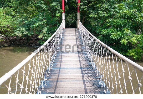 suspension bridge of wood chain and woods in the\
forest - vintage retro\
looks.
