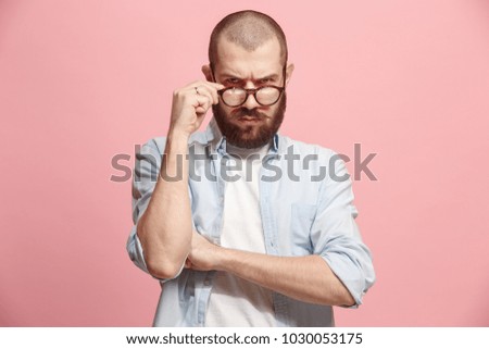 Suspicion. Doubt, mistrust, distrust concept. Doubtful man looking with disbelief expression . Young emotional man. Human emotions, facial expression concept. Studio. Isolated on trendy pink