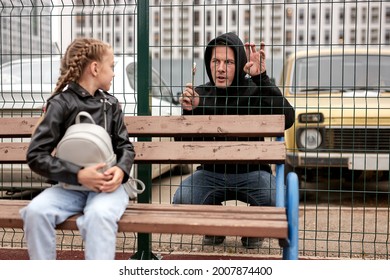 Suspicious adult man spying on kid girl at playground, space for text. Child in danger. focus on man looking at child girl, on street in city. child abuse, violence concept. pedophile in background