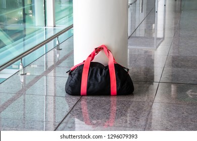 Suspicious Black And Red Bag Left Unattended In An Empty Hall. Concept Of Public Safety