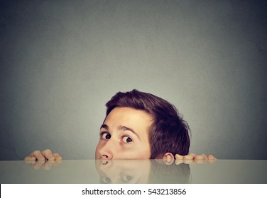 Suspicious Scared Man Peeking From Under The Table Hiding   
