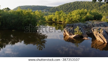 Susquehanna River facing west with boulders sticking out of the water and hills in the background