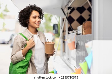 Sustainability, Eating And Eco Friendly Concept - Happy Smiling Woman Holding Reusable Green Shopping Bag And Takeaway Wok With Chopsticks Over Food Truck Background