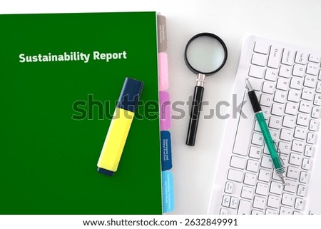 Sustainability  Report Concept featuring a document with page divider with title, keyboard, pen and magnifying glass 