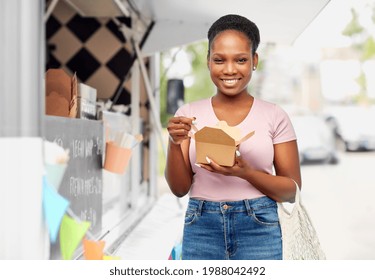 Sustainability, Shopping And Eco Friendly Concept - Happy Smiling African American Woman With Reusable String Bag Eating Takeaway Chinese Food Over Food Truck Background