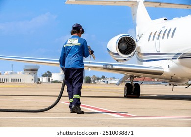 Sustainable Aviation Fuel (SAF). Technician refueling private jet with SAF at the airport. - Powered by Shutterstock