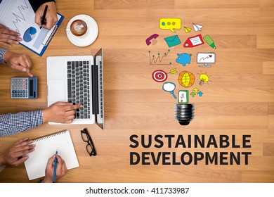 SUSTAINABLE DEVELOPMENT Business team hands at work with financial reports and a laptop - Shutterstock ID 411733987