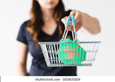 sustainable development and consumer buying habits concept, woman holding a shopping basket with recycle sign towards the camera shot at shallow depth of field