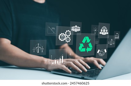 Sustainable development planning concept. Person using a laptop with virtual icons related to recycling, renewable energy, and environmental protection. ESG business sustainability investment strategy - Powered by Shutterstock