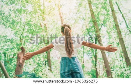 Sustainable eco-friendly fashion clothes woman feeling free with open arms in woods forest happy breating clean air. Travel tourist girl walking in natural healthy environment renewable resources.