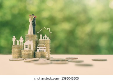 Sustainable Financial Goal For Family Life Or Married Life Concept : Miniature Wedding Couple, Parent & Child, A House Or Home, A Car On Rows Of Rising Coins, Depicts Savings Or Growth For New Family