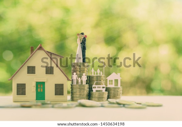 Sustainable financial goal for family life or\
married life concept : Miniature wedding couple, parent &\
child, a house or home, a car on rows of rising coins, depicts\
savings or growth for new\
family