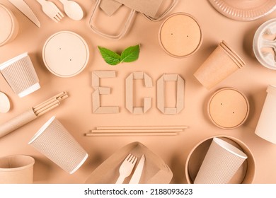 Sustainable Paper Packaging For Food Industry - Paper Utensils, Cups, Plates, Bags And Food Containers Over Light Brown Background. Flat Lay Style. Text ECO. Food Delivery Service 