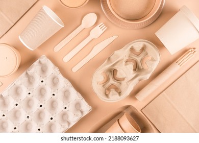 Sustainable Paper Packaging For Food Industry - Paper Utensils, Cups, Plates, Drinking Straws, Egg Boxes And Food Containers Over Light Brown Background. Flat Lay. Text ECO. Food Delivery Service 