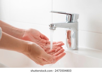 Sustainable use of natural resources banner. Clean tap water concept. Woman's hands with water near flow tap. Water running from chrome faucet. Using water resources concept, environmental protection - Powered by Shutterstock