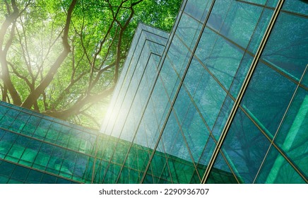 Sustainble green building. Eco-friendly building in modern city. Sustainable glass office building with tree for reducing carbon dioxide. Office with green environment. Corporate building reduce CO2. - Shutterstock ID 2290936707
