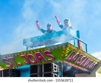 Susteren, Limburg/ The Netherlands - March 5 2019: Two Men In 90's Clothing And Long Hair Are Dancing On One Of The Participating Cars Of The Limburg Carnaval Car Championship.