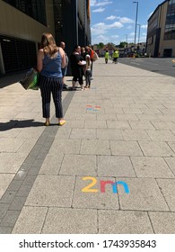 Sutton, Surrey, UK - May 25th 2020 : People Queuing Outside A Supermarket Keeping 2m Social Distance