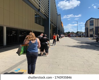 Sutton, Surrey, UK - May 25th 2020 : People Queuing Outside A Supermarket Keeping 2m Social Distance