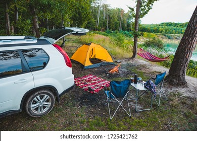 Suv Car At Lake Beach Camping Fire And Hammock Between Trees