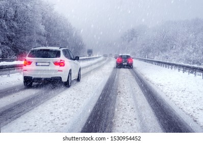 SUV Car Passing  On A German Highway With Snow Slush And Snow Fall, Winter Scenery