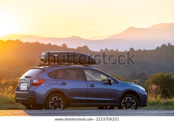 SUV car with roof rack luggage\
container for off road travelling parked at roadside at sunset.\
Road trip and getaway concept. Kyiv, Ukraine - September 19,\
2020.