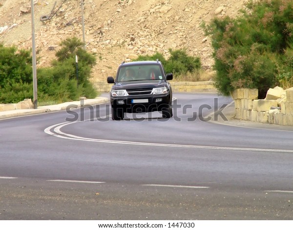 SUV driving around a\
bend