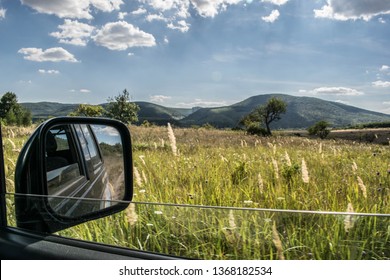 Suv Rear View Mirror Shot While Off Roading On A Beautiful Field.