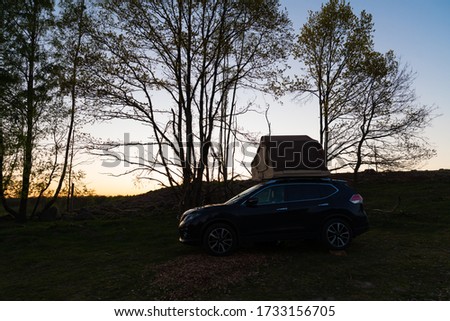 Suv with a roof tent in the wilderness in Sweden in the evening
