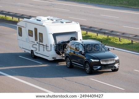SUV Towing Large Home Trailer on Highway for Road Trip