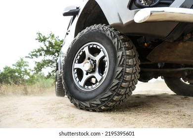 SUV wheel close up is on nature background in summer. off-road car tyre close up outdoor. mud tire close up is on off road car. 